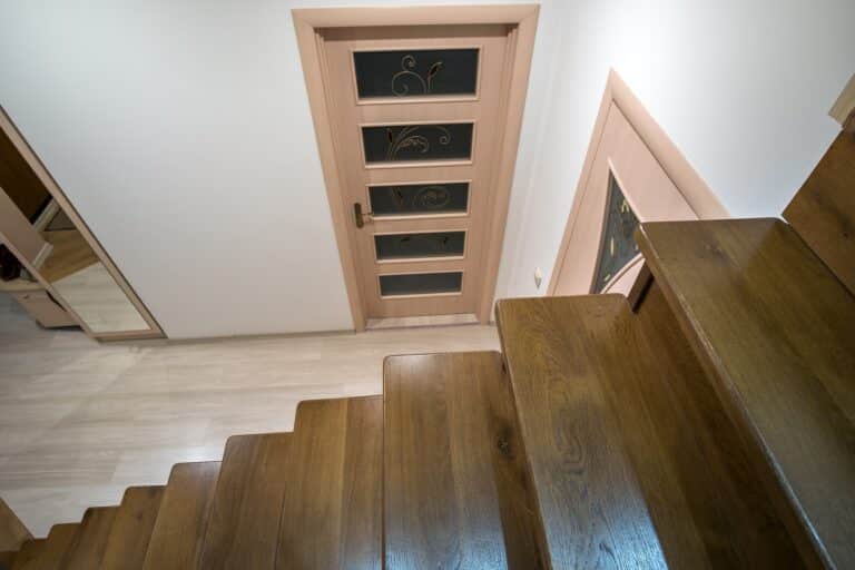 Interior of a house or appartment hallway with oak wooden stairs and room doors